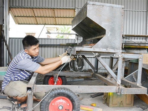 Anh Trần Văn Hảo sản xuất máy trồng củ đa năng. Ảnh: Nguyễn Tuấn Anh – TTXVN